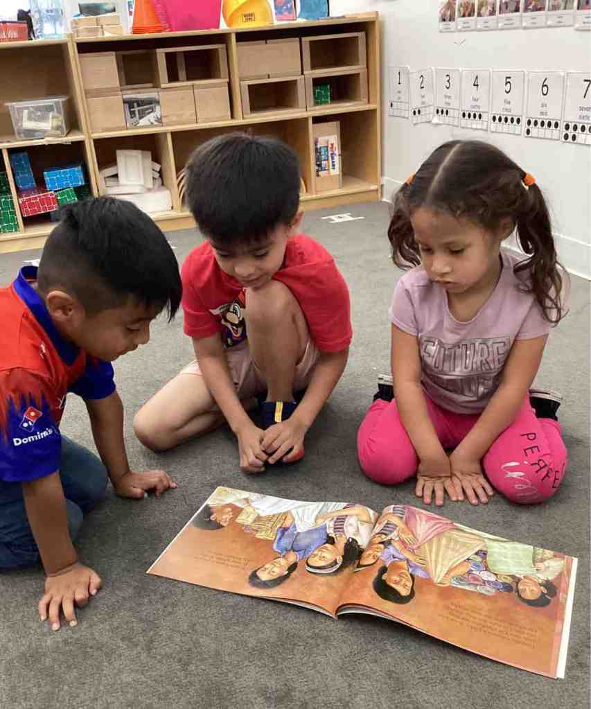 three kids read picture book together