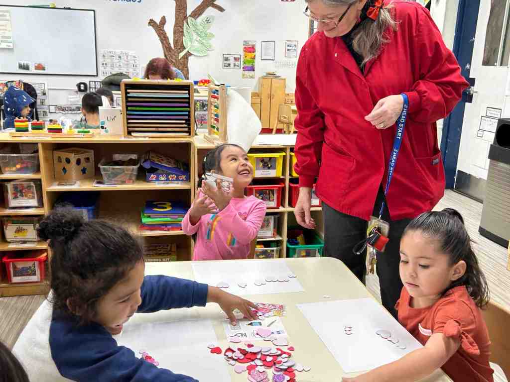 teacher looks at kids class project